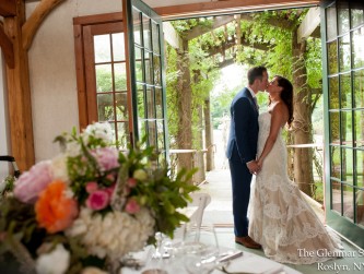 The bride and groom kissing in the doorway to the barn, The Glenmar Studio